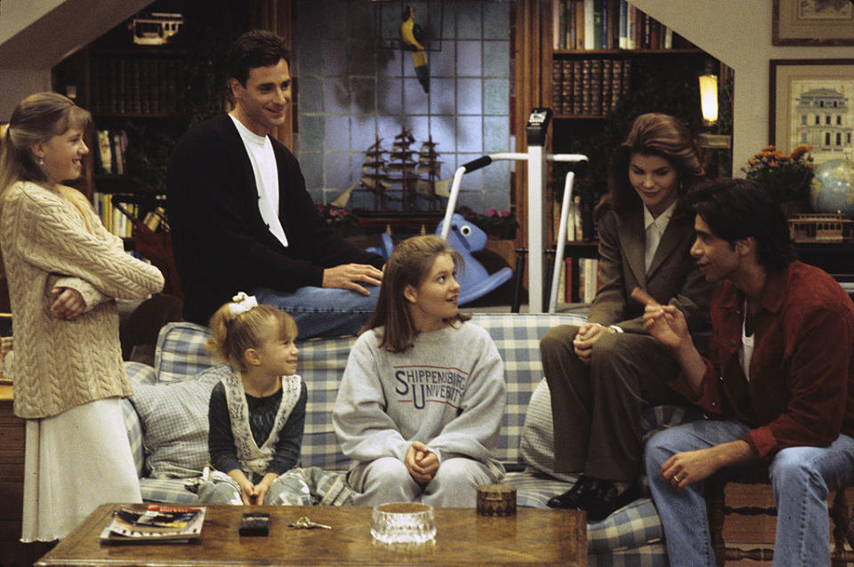 The Tanner family sitting on a plaid couch