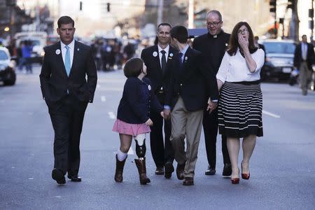 The family of Boston Marathon bombing victim Martin Richard (R) and Boston Mayor Marty Walsh (L) walk along Boylston Street following a ceremony at the site of the second bomb blast on the second anniversary of the bombings in Boston, Massachusetts April 15, 2015. REUTERS/Brian Snyder