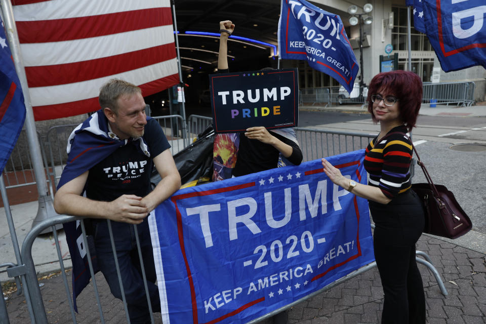 A passerby stops to speak with a few supporters of President Donald Trump protesting outside the Pennsylvania Convention Center, where vote counting continues, in Philadelphia, Monday, Nov. 9, 2020, two days after the 2020 election was called for Democrat Joe Biden. (AP Photo/Rebecca Blackwell)