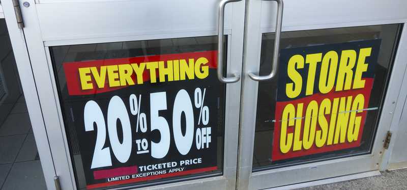 A store closing sign showing discounts