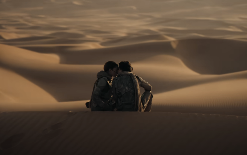 Paul and Chani kissing as they sit in the sand