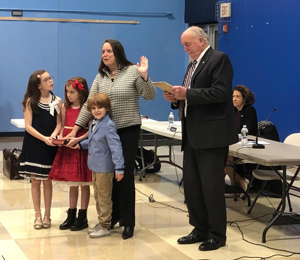 Tracey Moreen — accompanied by her children, from left to right: Harper, 9; Beckett, 7; and Fitz, 5 — takes the oath of office for the Mendham Township Committee, administered by township attorney John Mills, during the committee's reorganization at Mendham Township Middle School Thursday, Jan. 5, 2023.