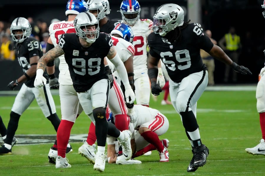 Las Vegas Raiders defensive tackle Adam Butler (69) and Las Vegas Raiders defensive end Maxx Crosby celebrate a sack against the New York Giants during the second half of an NFL football game, Sunday, Nov. 5, 2023, in Las Vegas. (AP Photo/Rick Scuteri)