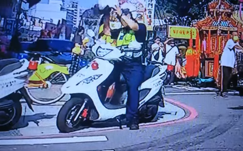 一名員警騎車前未發覺自己已經戴上安全帽，又拿起另一頂安全帽想戴上。（翻攝自臉書「爆怨公社」）