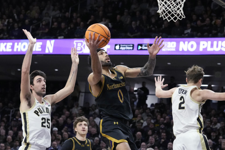 Northwestern guard Boo Buie (0) drives to the basket past Purdue guard Ethan Morton (25) during the first half of an NCAA college basketball game in Evanston, Ill., Friday, Dec. 1, 2023. (AP Photo/Nam Y. Huh)