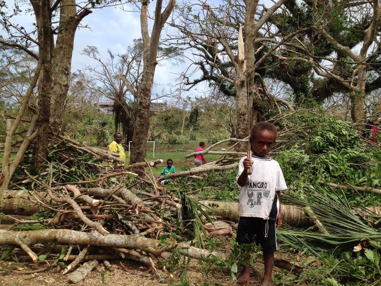 A child plays amongst the debris while residents deal with the damage to their homes in Seaside, near the Vanuatu capital of Port Vila, on March 14, 2015