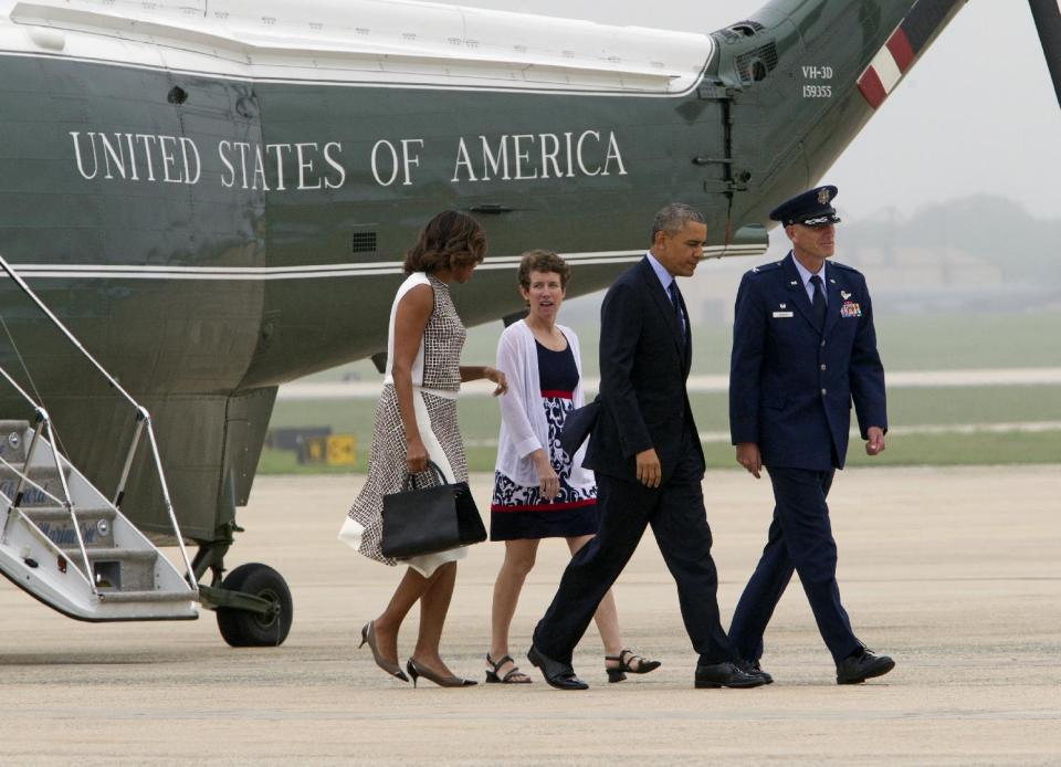 President Barack Obama and first lady Michelle Obama walk from Marine One with Col. David Almand and his wife Cathy to board Air Force One, Wednesday, May 14, 2014, at Andrews Air Force Base, Md., en route to Tarrytown, N.Y., where he will speak about the need for a 21st Century Transportation Infrastructure.. (AP Photo/Jose Luis Magana)