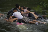 Migrants cross the Rio Bravo on an inflatable mattress into the United States from Matamoros, Mexico, on May 9, 2023. The image was part of a series by Associated Press photographers Ivan Valencia, Eduardo Verdugo, Felix Marquez, Marco Ugarte Fernando Llano, Eric Gay, Gregory Bull and Christian Chavez that won the 2024 Pulitzer Prize for feature photography. (AP Photo/Fernando Llano)