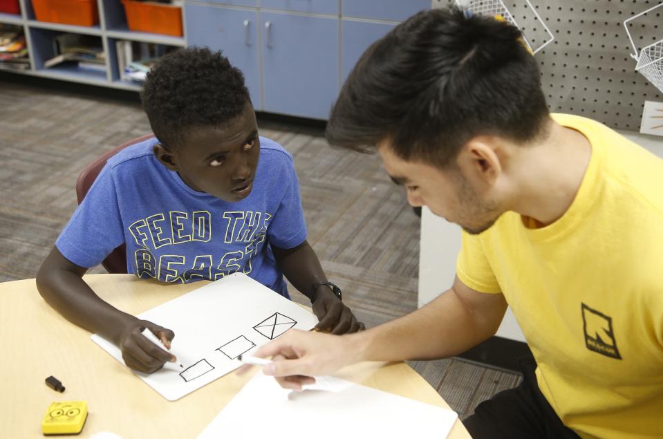 Ali Ali, left, works with an instructor at Valencia Newcomer School during class Thursday, Oct. 17, 2019, in Phoenix. Children from around the world are learning the English skills and American classroom customs they need to succeed at so-called newcomer schools. Valencia Newcomer School in Phoenix is among a handful of such public schools in the United States dedicated exclusively to helping some of the thousands of children who arrive in the country annually. (AP Photo/Ross D. Franklin)