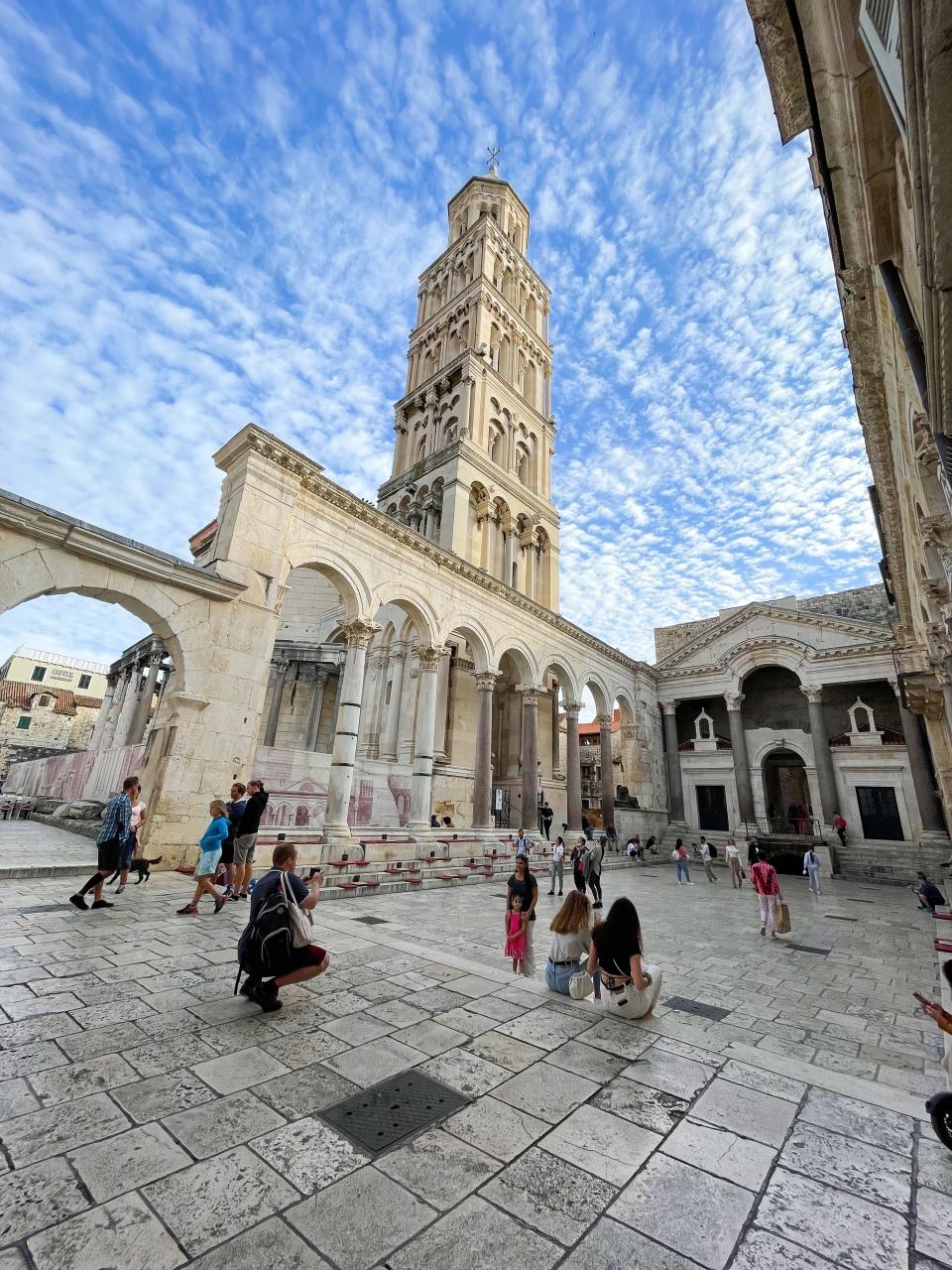 The square of a European city with old buildings looking up at the sky.