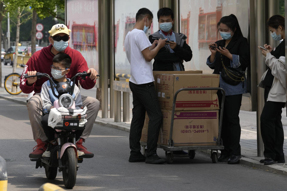 Residents wearing mask are seen on the street on Thursday, May 19, 2022, in Beijing. (AP Photo/Ng Han Guan)