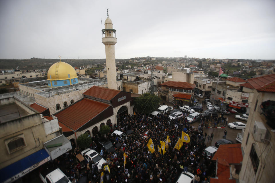 Palestinians gather for the funeral of policeman Tariq Badwan during his funeral in the West Bank village of Azoun near Qalqilya, Friday, Feb. 7, 2020. Badwan was shot while standing at the entrance of a police station in Jenin, where Israeli forces clashed with Palestinians while demolishing the home of an alleged militant. He did not appear to have been involved in the clashes. (AP Photo/Majdi Mohammed)