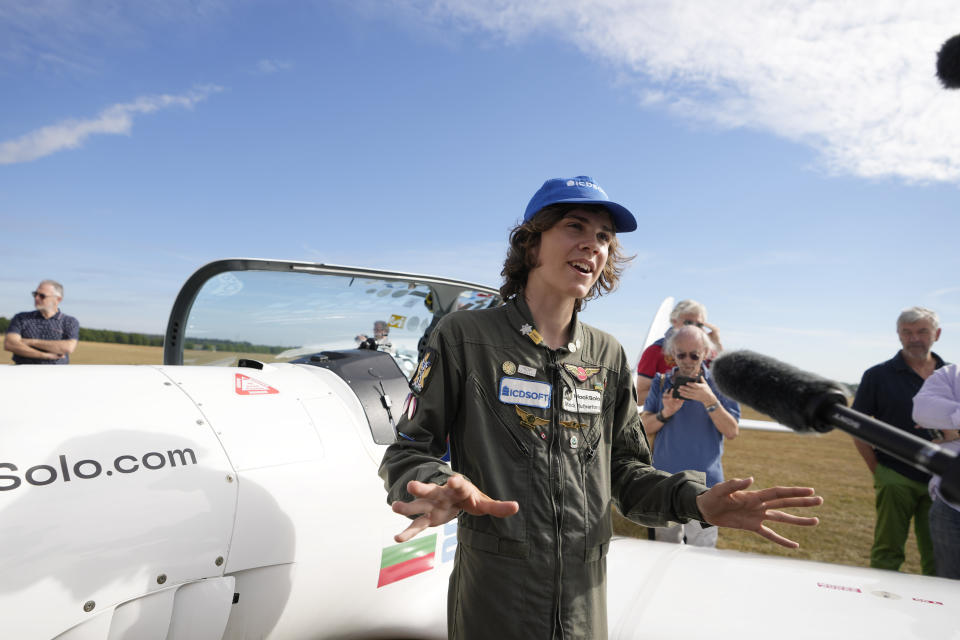 Seventeen year old Anglo-Belgian pilot, Mack Rutherford, speaks with the media after landing at the Buzet airfield in Pont-A-Celles, Belgium, Tuesday, Aug. 23, 2022. Rutherford landed in Belgium before flying on to Slovakia and Sofia, Bulgaria, for the final leg of his Guinness World Record attempt to be the youngest person to the fly around the world solo in a small plane. (AP Photo/Virginia Mayo)