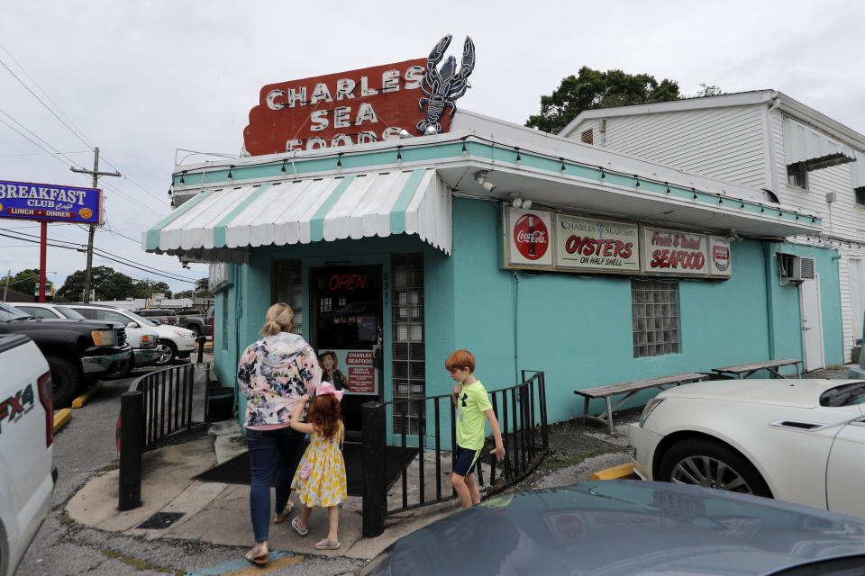 Customers enter Charles Seafood Restaurant for indoor sit-down service, for the first time since the state shutdown, in Harahan, La., Friday, May 15, 2020. Once a hot spot for coronavirus infections, Louisiana is officially easing up Friday on economically devastating business closures and public gathering restrictions that Gov. John Bel Edwards credits with slowing the spread of the virus. (AP Photo/Gerald Herbert)