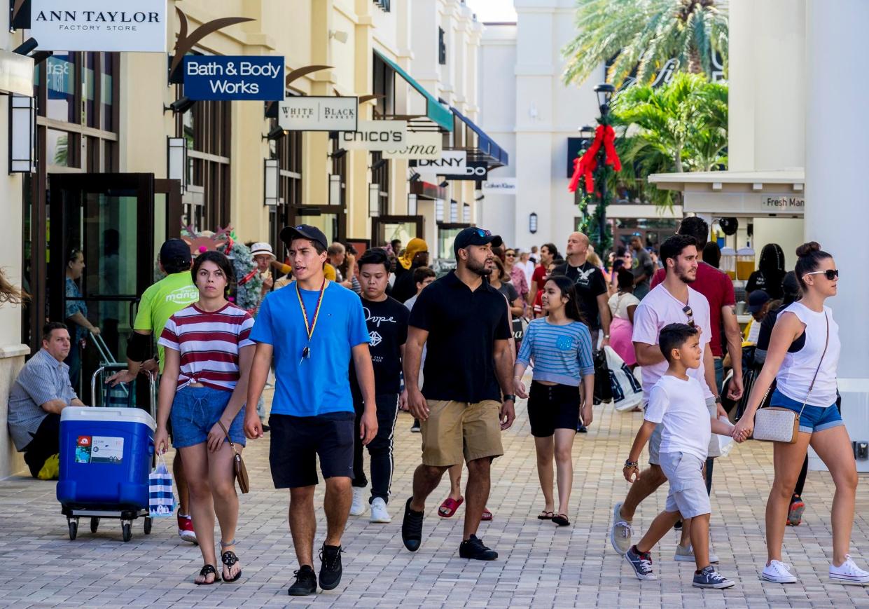 Shoppers make their way around the Tanger Outlets.