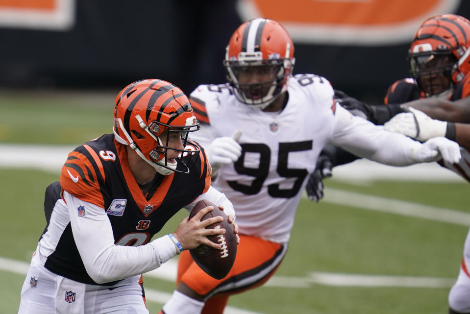 Cincinnati Bengals quarterback Joe Burrow (9) is chased by Cleveland Browns defensive end Myles Garrett (95) during the first half of an NFL football game, Sunday, Oct. 25, 2020, in Cincinnati. (AP Photo/Michael Conroy)