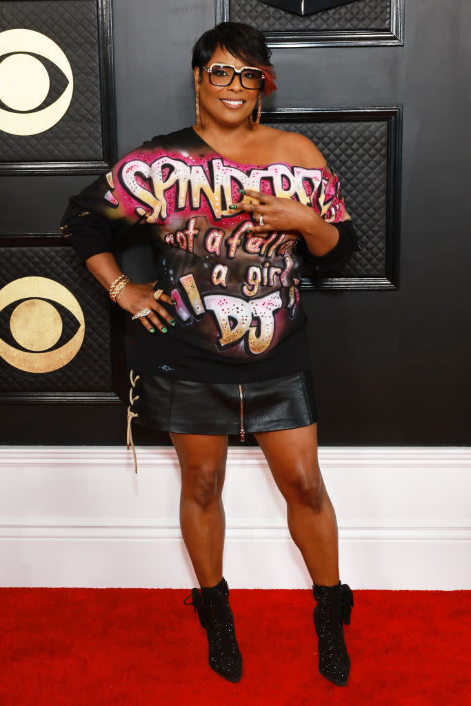 DJ Spinderella in short black leather skirt and top printed with her name saying: not a fella a girl &#39;DJ.&#39;
