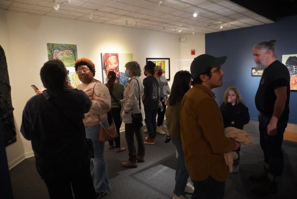 Attendees view artwork and photographs during the Black Space Art Exhibition, which opened on Friday and features the works of 17 black artists at the Historic Thomas Center at 302 NE Sixth Ave. in Gainesville.