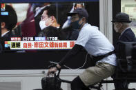 A man rides a bicycle past a public TV showing Fumio Kishida, former foreign minister, during the Liberal Democratic Party's presidential election Wednesday, Sept. 29, 2021, in Tokyo. Kishida has won the governing party leadership election and is set to become the next prime minister. The Japanese letters read: "Fumio Kishida new LDP president." (AP Photo/Eugene Hoshiko)