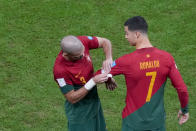 Portugal's Pepe places the captain armband on the arm of teammate Cristiano Ronaldo during the World Cup round of 16 soccer match between Portugal and Switzerland, at the Lusail Stadium in Lusail, Qatar, Tuesday, Dec. 6, 2022. (AP Photo/Frank Augstein)