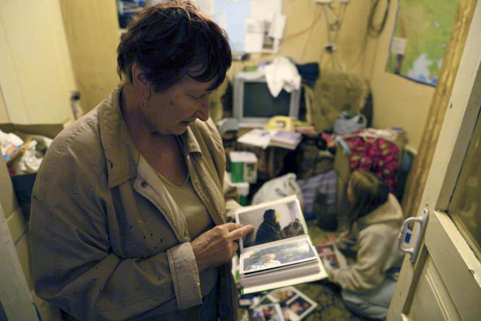 Tetiana Lukashova, 66, shows pictures of her family in the village of Hroza near Kharkiv, Ukraine, Friday, Oct. 6, 2023. Her daughter and son-in-law were killed as the Russian rocket hit a village store and cafe in one of the deadliest attacks in recent months, killing at least 51 civilians. (AP Photo/Alex Babenko)