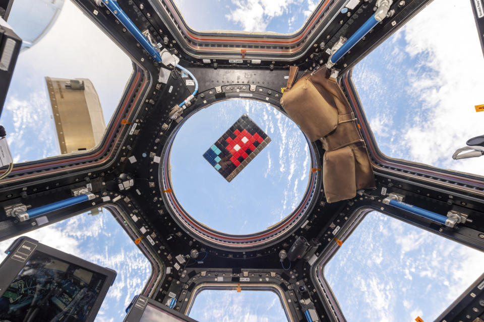 Un mosaico del artista francés Invader flota en la Estación Espacial Internacional en 2015. Invader, uno de los artistas franceses más populares, ha pegado mosaicos en las paredes de la capital francesa, el mundo e incluso los ha llevado a la Estación Espacial Internacional. (Samantha Cristoforetti/ESA-NASA vía AP)