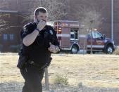 A Roswell police officer responds as law enforcement personnel set up a perimeter following an early morning shooting at Berrendo Middle School in Roswell, New Mexico, January 14, 2014. REUTERS/Mark Wilson/Roswell Daily Record