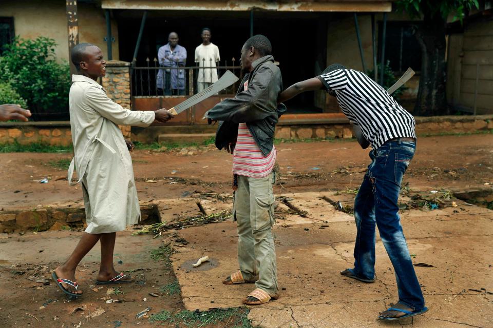 FILE - In this Friday, Dec. 13, 2013 file photo, Muslim men organized in militias with machetes rough up a Christian man while checking him for weapons in the Miskine neighbourhood of Bangui, Central African Republic. Sub-Saharan Africa has seen a very violent start to 2014 with raging conflicts in South Sudan and Central African Republic - the death tolls are huge and the individual incidents gruesome, with one estimate saying nearly 10,000 have been killed in South Sudan in a month of warfare. (AP Photo/Jerome Delay, File)