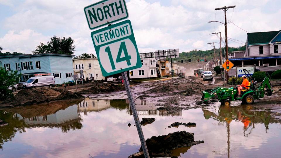 PHOTO: A small tractor clears water from a business as flood waters block a street, July 12, 2023, in Barre, Vt. (Charles Krupa/AP)