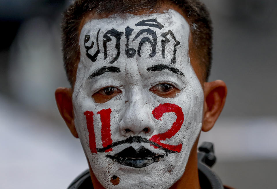 A pro-democracy supporter with his face painted with "Stop 112", describing the section in the Thai criminal code for lese majesty laws, participates in a rally in Bangkok, Thailand, Wednesday, March 24, 2021, ahead of indictment against 13 protest leaders on Thursday for allegations of sedition and defaming the monarchy. (AP Photo/Sakchai Lalit)