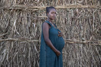 Ethiopian Amhara refugee Blaines Alfao Eileen, 8-months pregnant and who fled the conflict in Ethiopia, stands near her shelter, at Um Rakuba refugee camp in Qadarif, eastern Sudan, Monday, Nov. 23, 2020. Tens of thousands of people have fled a conflict in Ethiopia for Sudan, sometimes so quickly they had to leave family behind. There is not enough to feed them in the remote area of southern Sudan that they rushed to. (AP Photo/Nariman El-Mofty)