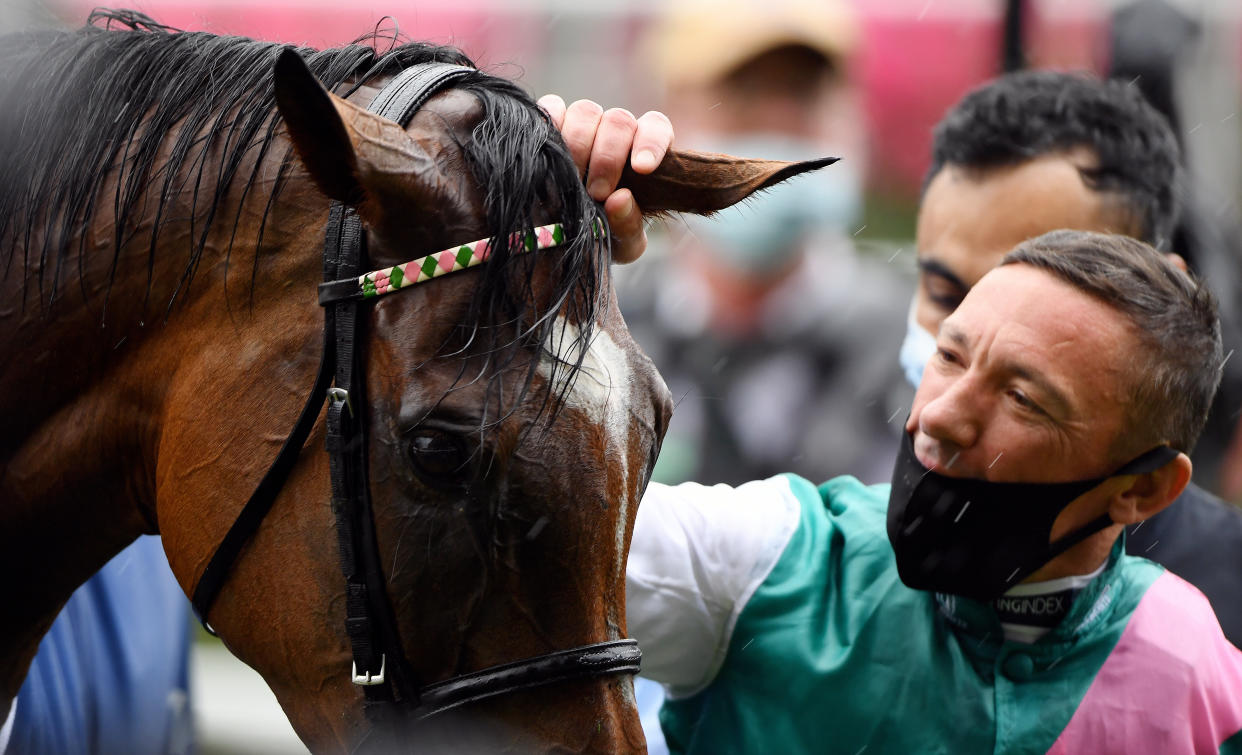 Frankie Dettori strokes Enable as they celebrate winning the King George VI and Queen Elizabeth QIPCO Stakes at a rainy Ascot