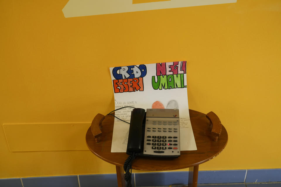 A phone sits on a paper sheet reading: "I believe in the human beings, today people judges you for the image that you have, they see only masks they don't know even who you are" inside the Chicco community of L'Arche, an International charity that helps people with intellectual disabilities, in Ciampino, near Rome, Wednesday, March 22, 2023. The findings of expert reports commissioned by L’Arche itself reveal that their founder, Jean Vanier, perverted Catholic doctrine to justify his own sexual compulsions and abuse women and that the movement he created had at its core a secret, a mystical-sexual “sect” founded for the precise purpose of hiding the sect’s deviant activities from church authorities. (AP Photo/Gregorio Borgia)