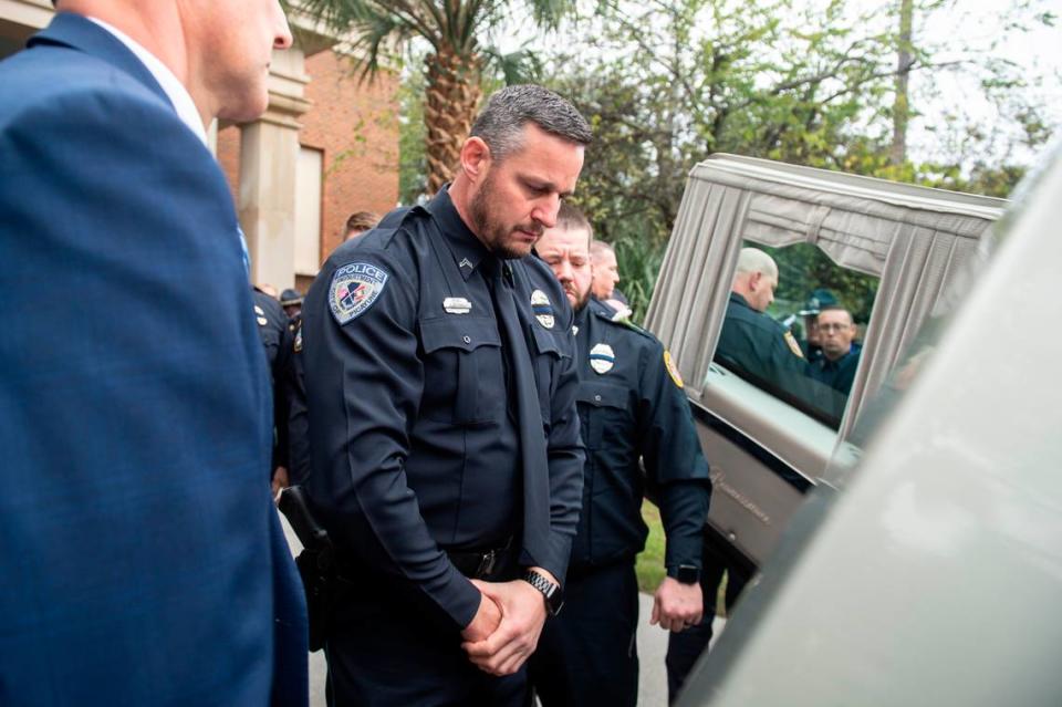 Picayune Police Officer Saltarelli prays as the caskets of Bay St. Louis police officers Sgt. Steven Robin and Branden Estorffe are placed in hearses following their funeral at the Bay St. Louis Community Center in Bay St. Louis on Wednesday, Dec. 21, 2022. Robin and Estorffe were killed responding to a call at a Motel 6 on Dec. 14.