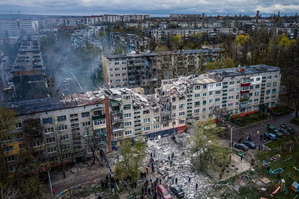 This aerial view shows rescuers on top of a partially destroyed residential building, after a shelling in Sloviansk, on 14 April 2023, amid Russia’s military invasion on Ukraine (AFP via Getty Images)