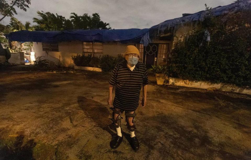 El veterano Kenneth Heller, de 78 años, frente a su casa en North Miami, con una lona azul cubriendo todo el tejado. Carece de recursos para arreglarlo.