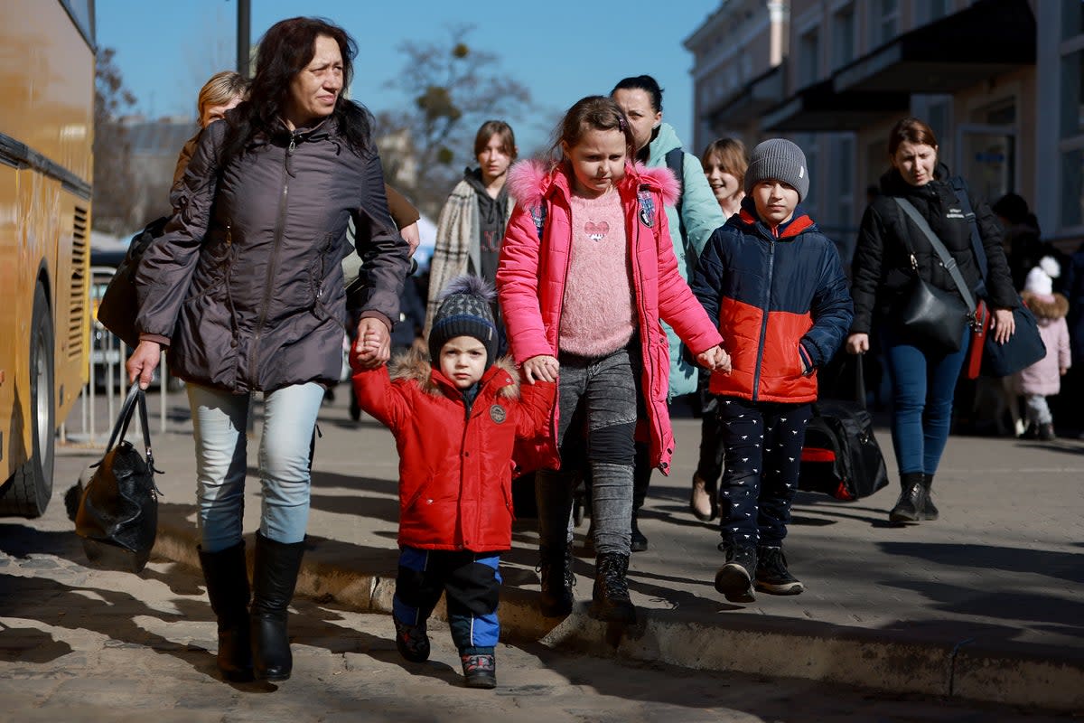 People from the town of Zaporizhzhia walk together after fleeing from their home town on the train (Getty)