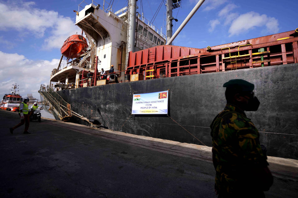 A police command stands by a ship that carried emergency supplies granted as humanitarian aid by Indian government to Sri Lankan people at a port in Colombo, Sri Lanka, Sunday, May 22, 2022. The consignment, which consists of 9,000 MT of rice, 50 MT of milk powder and more than 25 MT of drugs and other medical supplies. (AP Photo/Eranga Jayawardena)