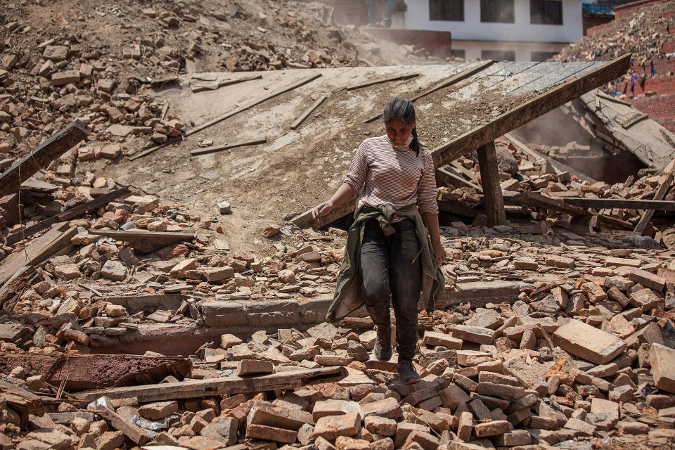 A volunteer walks on top of the debris of a collapsed temple at Basantapur Durbar Square on April 27, 2015 in Kathmandu, Nepal.   (Photo by Omar Havana/Getty Images)