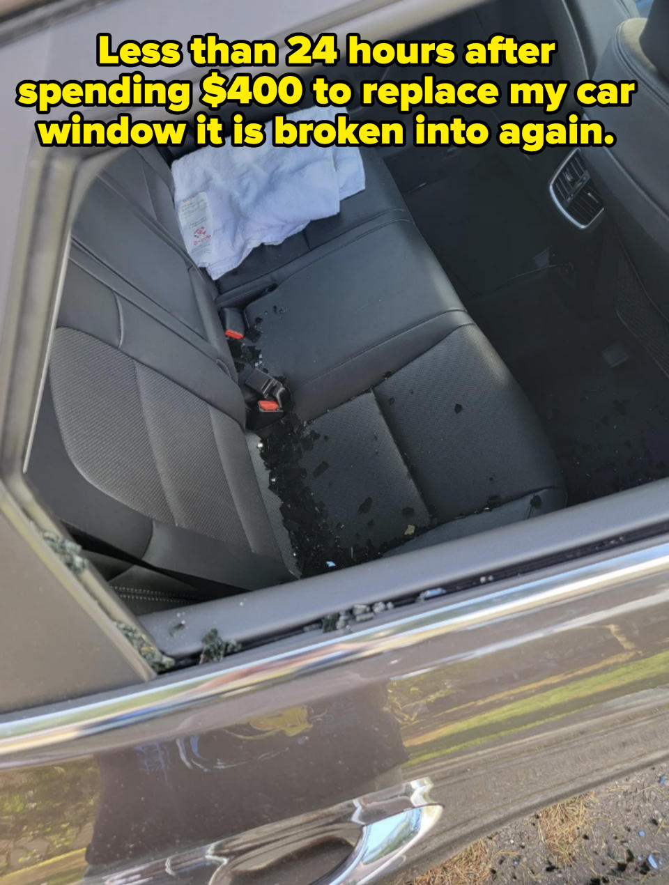 Car's back seat through an open door, with debris and a white towel on the seat