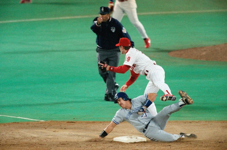 Philadelphia Phillies shortstop Kevin Stocker turns a double play on Toronto Blue Jays’ Pat Borders and gets Juan Guzman out at first after his bunt in the third inning of Game 5 of the World Series, in Philadelphia’s Veterans Stadium, Oct. 21, 1993. (AP Photo/George Widman)