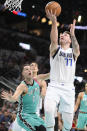 Dallas Mavericks' Luka Doncic (77) goes to the basket against San Antonio Spurs' Zach Collins during the first half of an NBA basketball game Saturday, Dec. 31, 2022, in San Antonio. (AP Photo/Darren Abate)