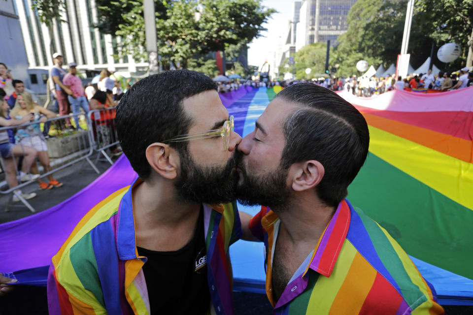 FILE - Revelers kiss during the annual gay pride parade along Paulista avenue, in Sao Paulo, Brazil, Sunday, June 23, 2019. While some cities host events throughout the month or even at other times of the year, many of the nation's largest cities, including New York, San Francisco, Chicago, Denver and Minneapolis, hold their marches on the last weekend of June. Pride events are found globally as well, in places including Sao Paulo, Tel Aviv, Madrid and Toronto. (AP Photo/Nelson Antoine, File)