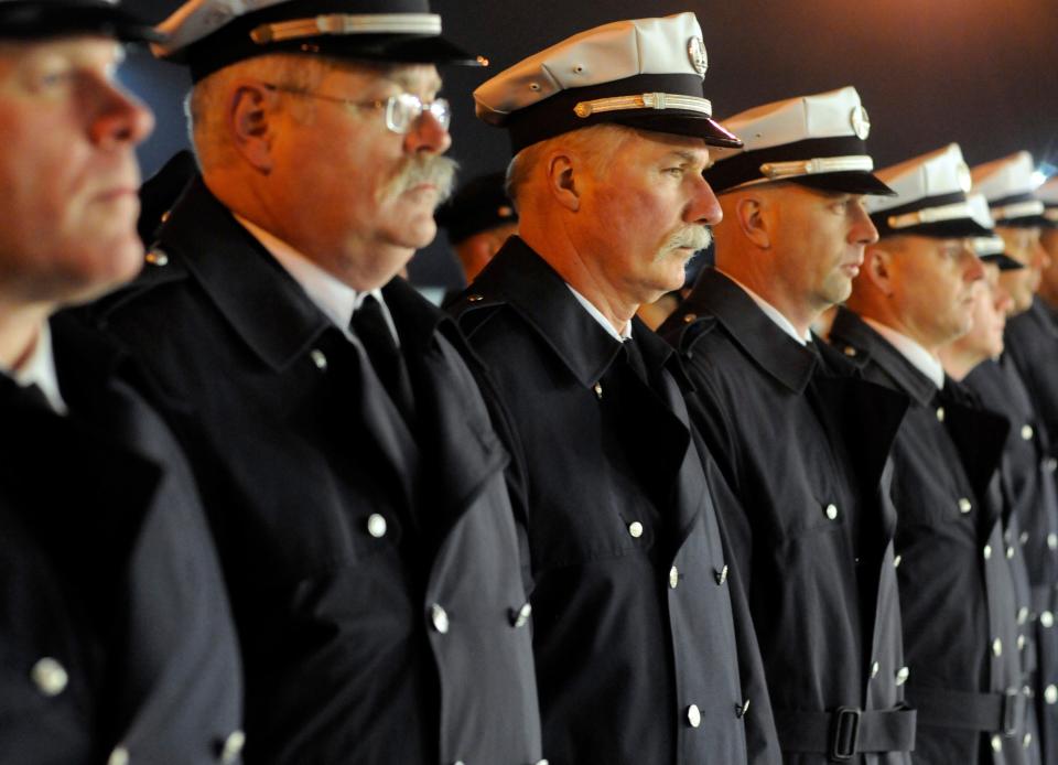 Retired Worcester Fire Department Captain Paul Berube, center, during the moment of silence of the 15th anniversary of the Worcester Cold Storage and Warehouse fire at Franklin Street Station on Dec. 3, 2014.