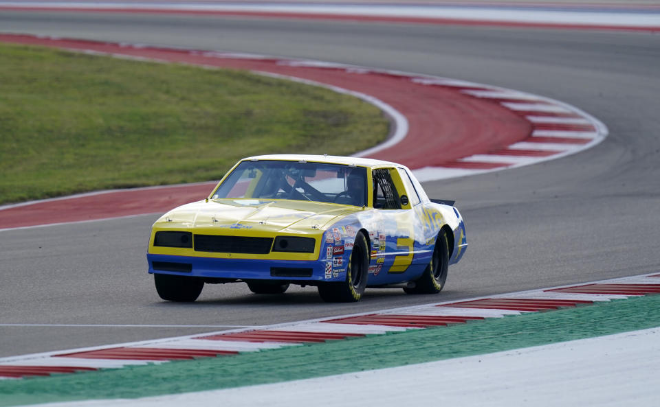 McLaren driver Daniel Ricciardo, of Australia, drives the late NASCAR driver Dale Earnhardt's iconic 1984 No. 3 Wrangler Chevrolet Monte Carlo before an open practice for the Formula One U.S. Grand Prix auto race at the Circuit of the Americas, Saturday, Oct. 23, 2021, in Austin, Texas. Ricciardo was allowed to drive the car as a reward from his McLaren boss, Zak Brown, for winning his first race with the team. (AP Photo/Eric Gay)