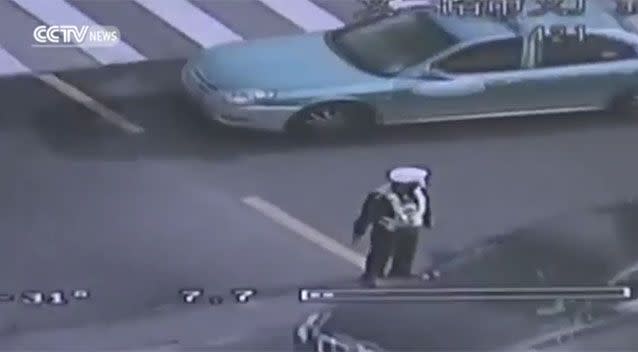 The officer stood close to the crack as he shepherded cars away. Source: CCTV