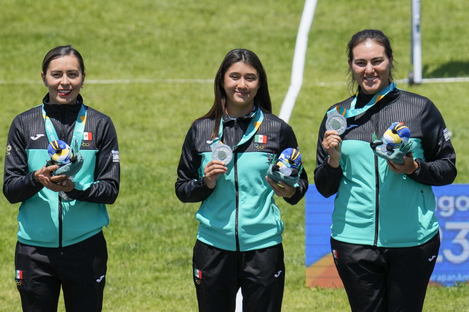 Desde la izquierda, las mexicanas Aida Román, Angela Ruiz y Alejandra Valencia posan con sus medallas de oro de la modalidad recurvo por equipos del tiro con arco de los Juegos Panamericanos en Santiago, Chile, el sábado 4 de noviembre de 2023. (AP Foto/Esteban Félix)
