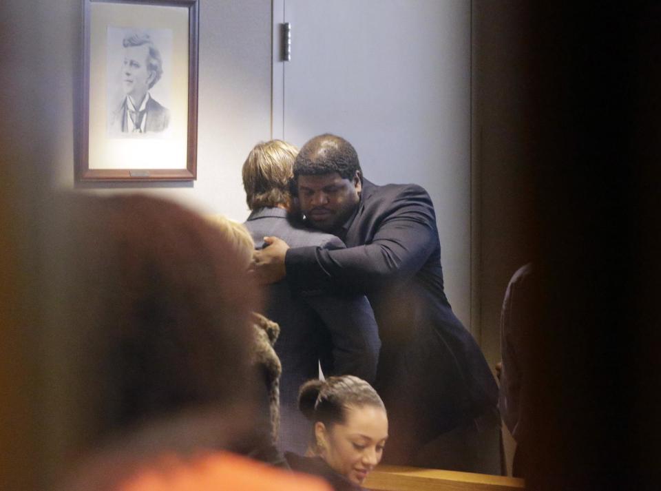 Former Dallas Cowboys NFL football player Josh Brent, right, hugs Dallas Cowboys linebacker Sean Lee in court after closing arguments in his intoxication manslaughter trial Tuesday, Jan. 21, 2014, in Waco, Texas. The jury has begun deliberating in Brent's intoxication manslaughter trial after lawyers wrapped up their closing arguments Tuesday morning. Prosecutors accuse the former defensive tackle of drunkenly crashing his Mercedes near Dallas during a night out in December 2012, killing his good friend and teammate, Jerry Brown. (AP Photo/LM Otero)