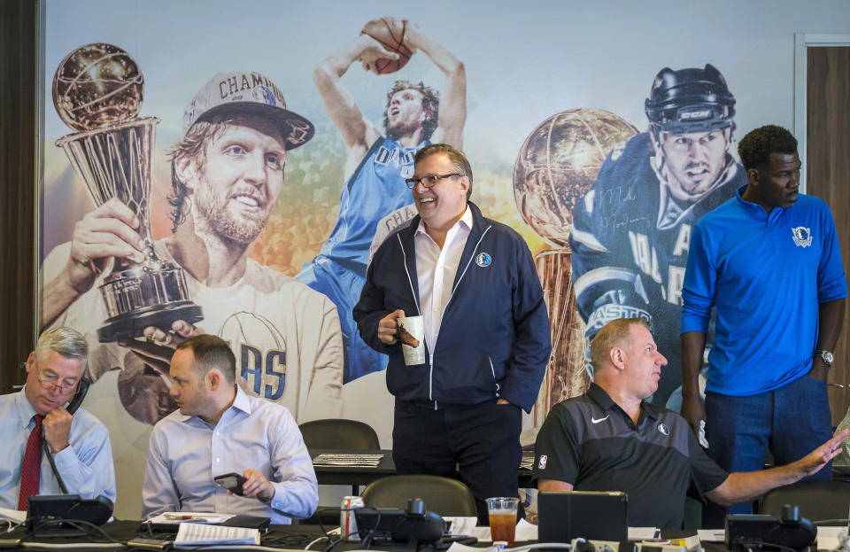 FILE - Dallas Mavericks President Donnie Nelson, center, joins, from left, assistant general manager Keith Grant, director of scouting Jason White, director of player personnel Tony Ronzone and vice president of basketball operations Michael Finley, in Dallas, before the NBA basketball draft got underway in New York, in this Thursday, June 20, 2019, file photo. Mavericks general manager Donnie Nelson, instrumental in the club's acquisitions of Dirk Nowitzki and Luka Doncic, is leaving the organization after 24 seasons. The Mavericks said Wednesday, June 16, 2021, the club and Nelson agreed to part ways, with owner Mark Cuban saying the son of former coach Don Nelson was “instrumental to our success and helped bring a championship to Dallas.”(Smiley N. Pool/The Dallas Morning News via AP, File)