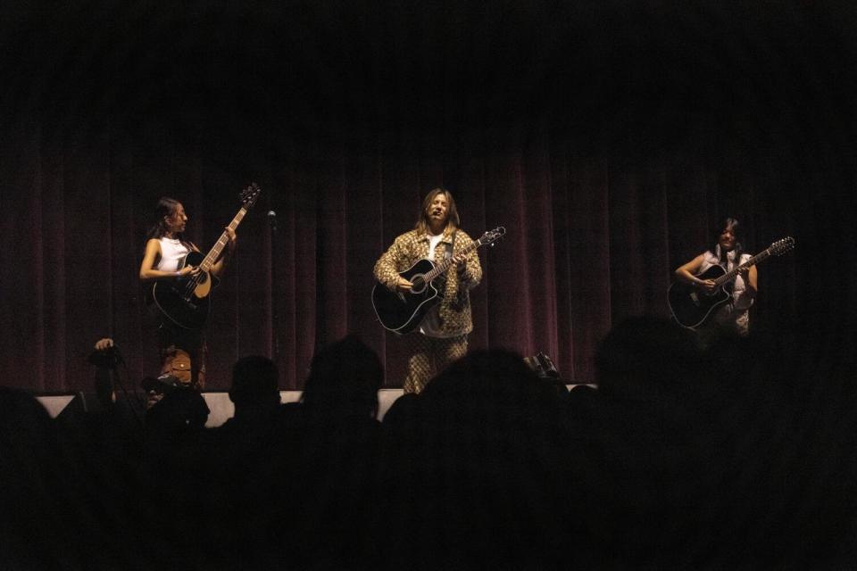 Members of Conexión Divina performing on a stage in front of a crowd.